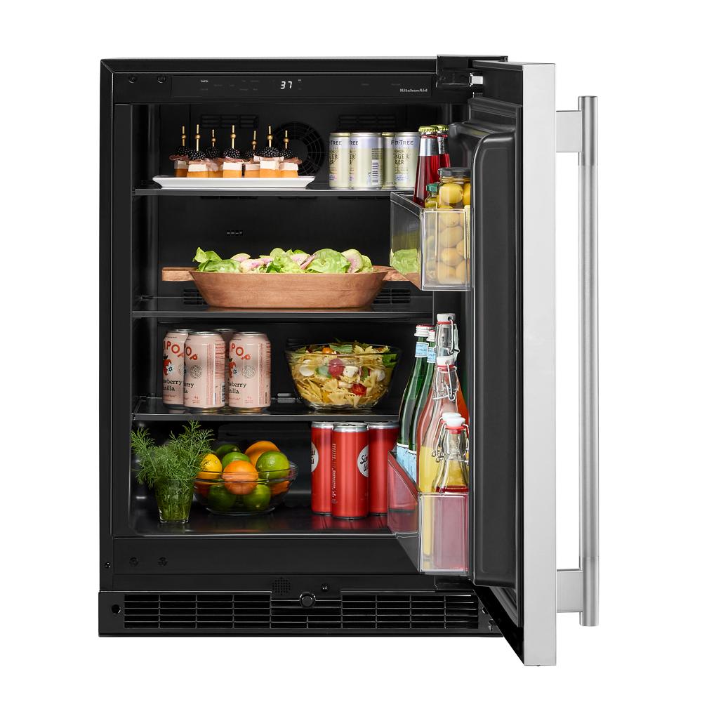 Open 24-inch undercounter refrigerator with stainless steel door showing organized shelves with beverages and snacks