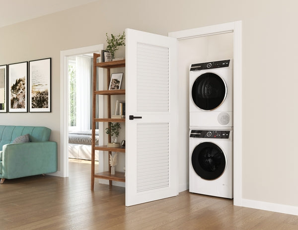 Stacked compact front load washer and dryer units in white inside a small laundry closet in a modern home.
