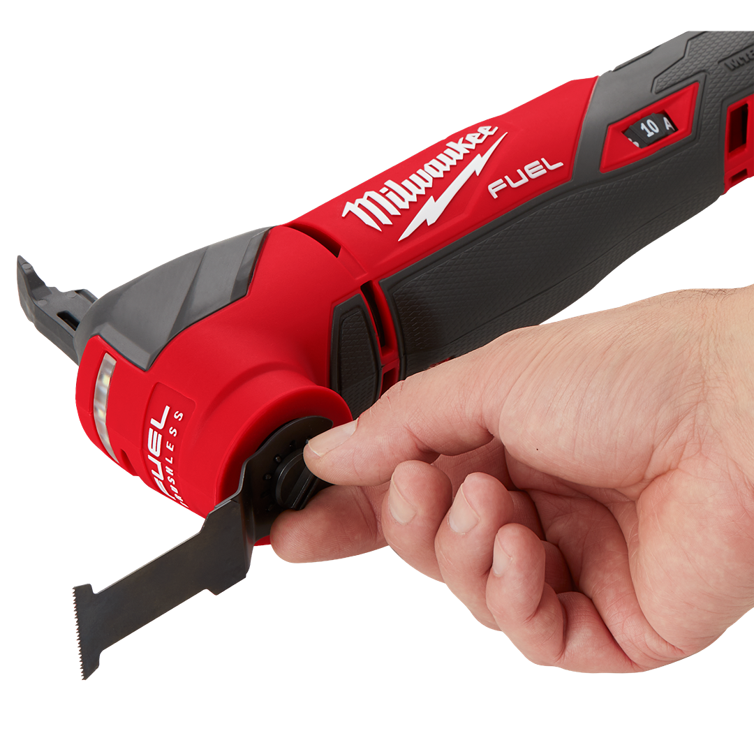Hand adjusting blade on red and black Milwaukee M18 FUEL oscillating multi tool for home improvement tasks