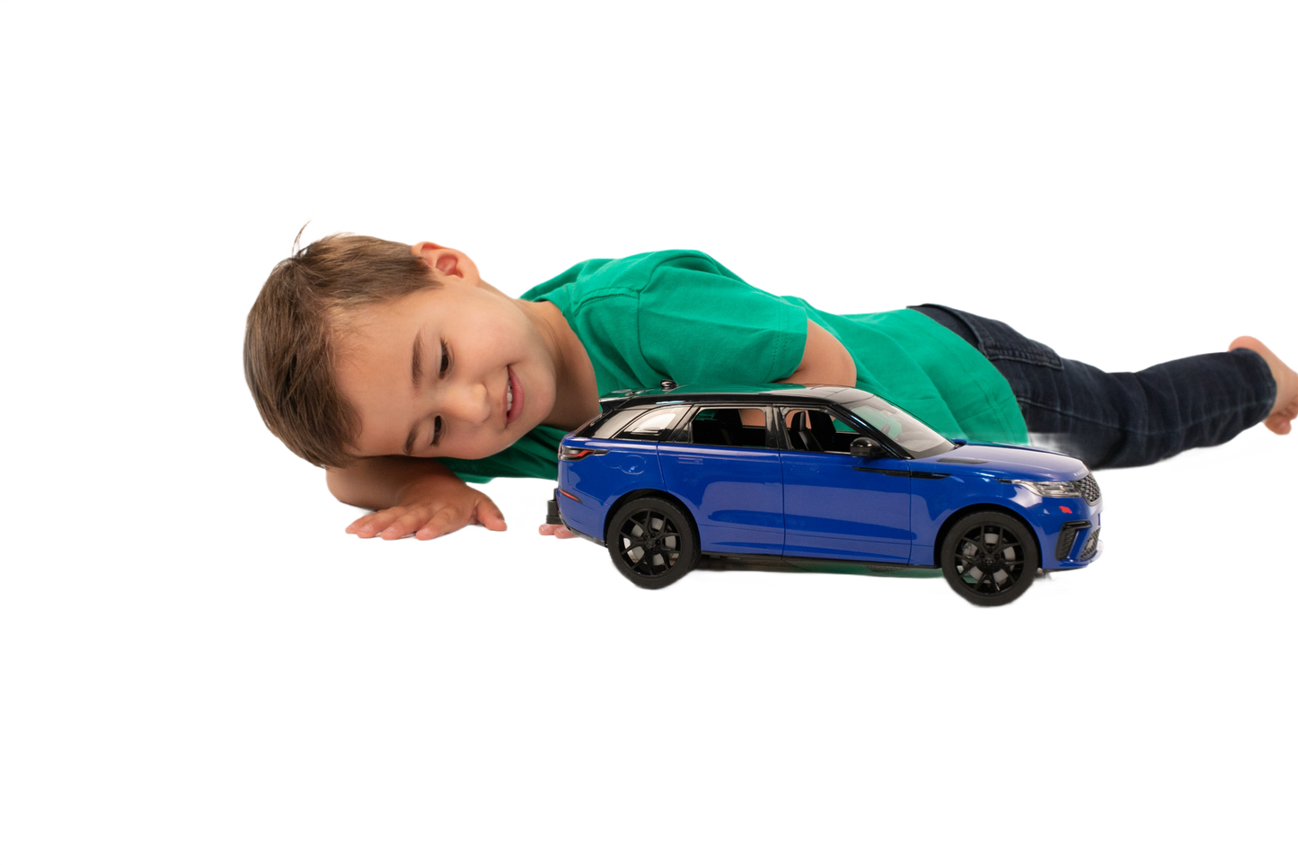 Child lying next to detailed blue Bruder Range Rover Velar toy car for play and display purposes
