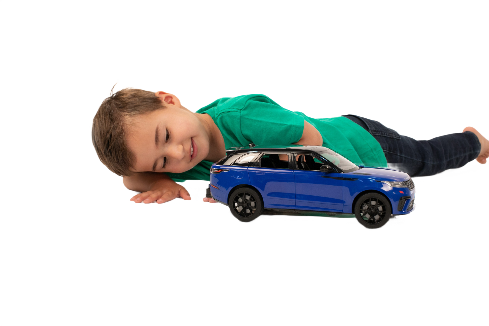 Child lying next to detailed blue Bruder Range Rover Velar toy car for play and display purposes