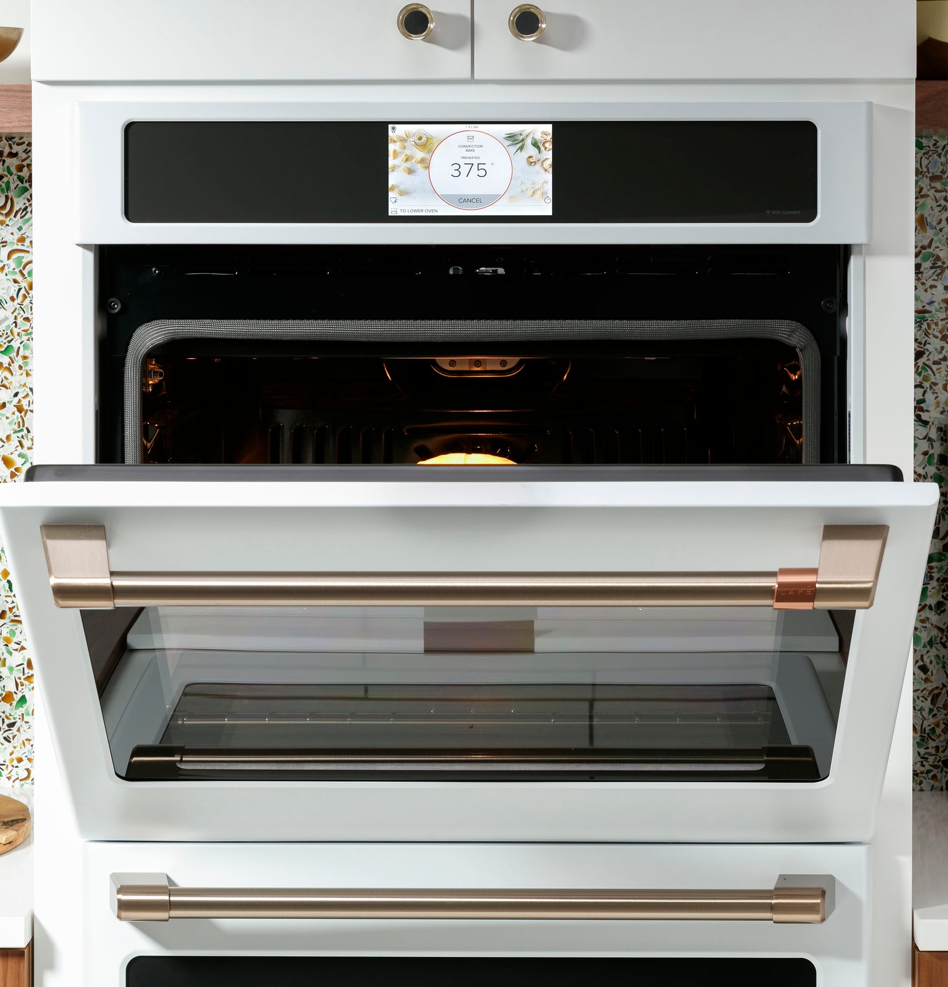 Built-in white convection double wall oven with touchscreen displaying 375°F and open door in modern kitchen setting