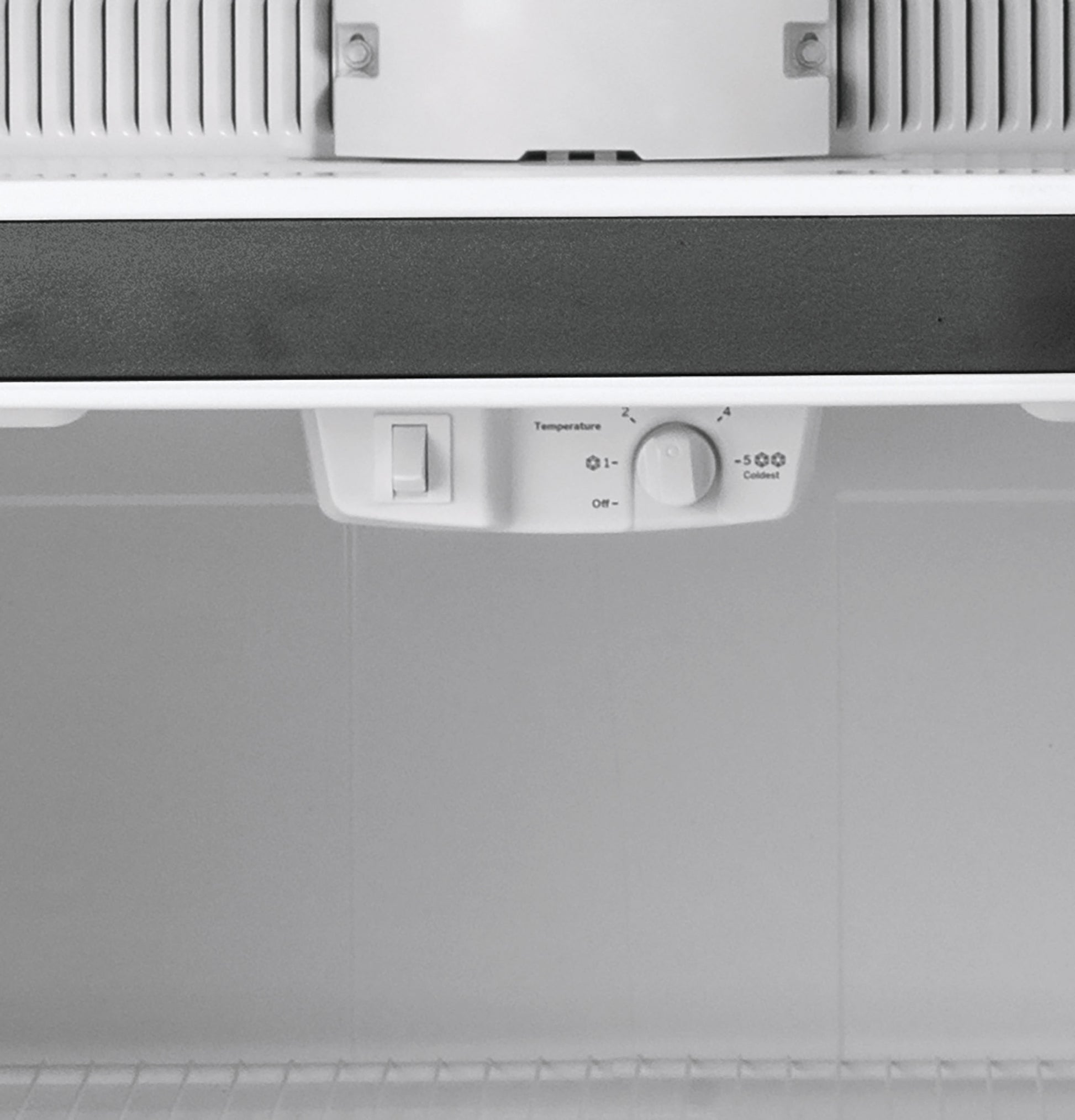 Close-up of refrigerator interior temperature control dial and switch with white interior background for appliance use