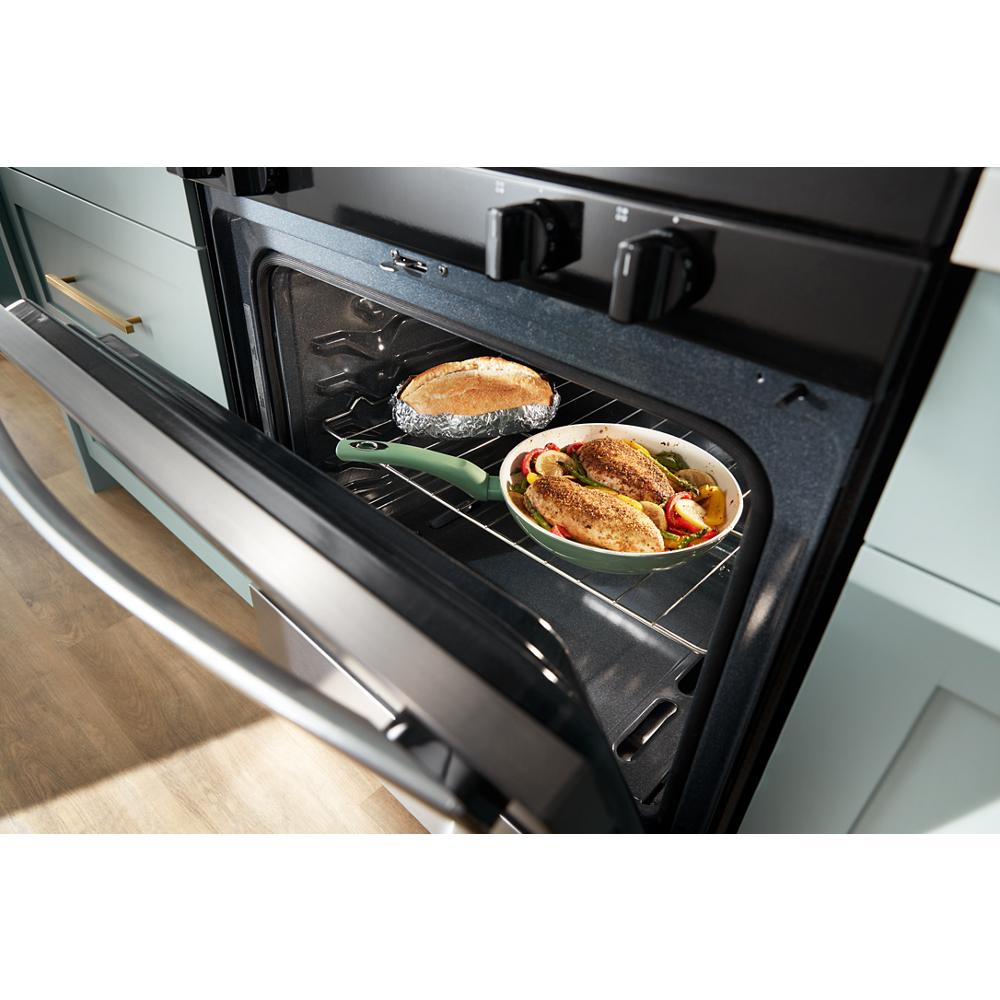 Open black gas oven with baked chicken and a pie inside, part of kitchenware and home improvement appliances collection