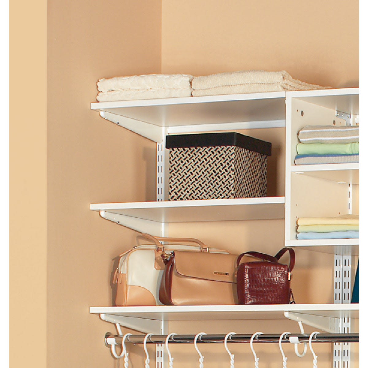 White melamine closet shelves with towels, bags, and storage box in organized closet space for storage and organization