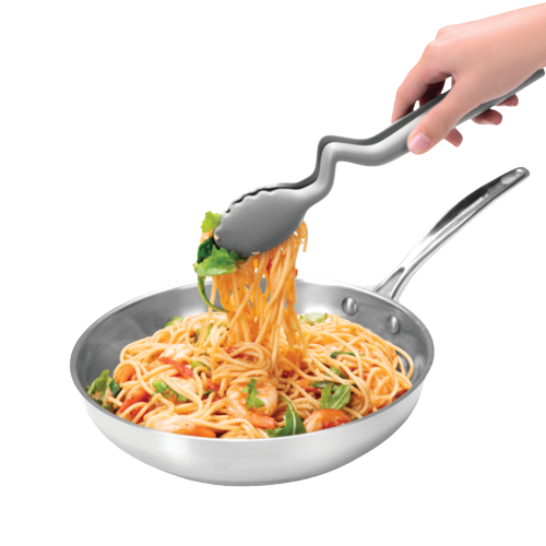 Curved black kitchen tongs lifting spaghetti with vegetables from a stainless steel frying pan in kitchenware setting