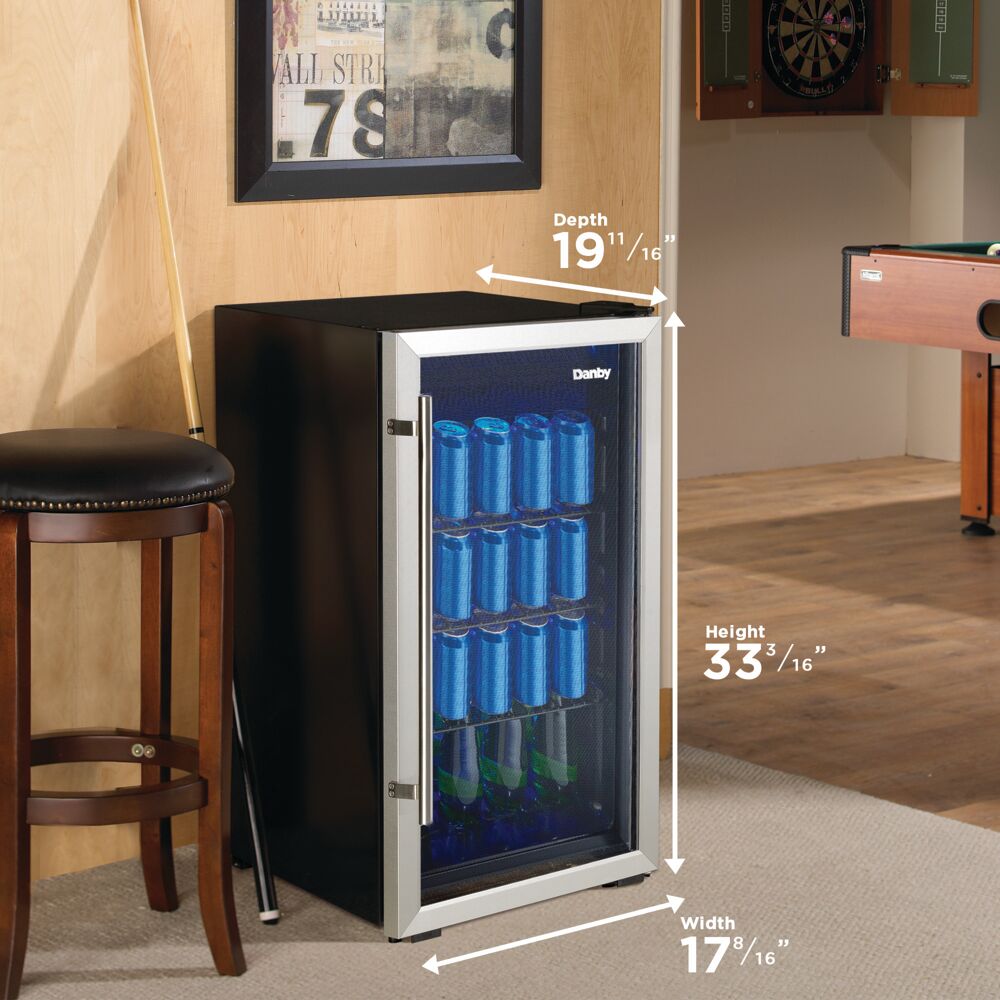 Compact beverage center with tempered glass door and wire shelves stocked with blue cans and green bottles in home bar setting