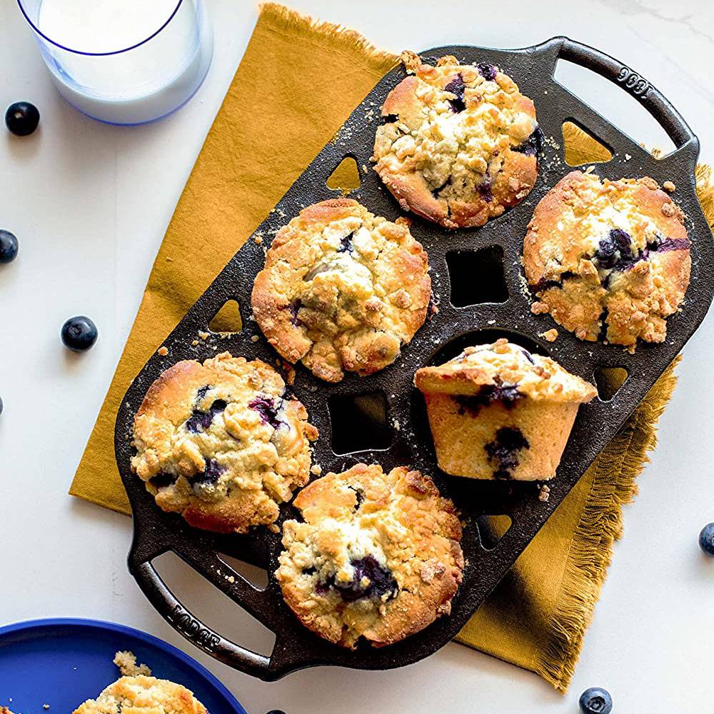Seasoned cast iron muffin pan with six blueberry muffins on mustard cloth in kitchenware and tools collections
