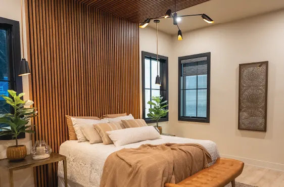 Cozy bedroom featuring a wooden slat accent wall, neutral bedding with layered pillows, modern black-framed windows, and contemporary ceiling and bedside lighting.