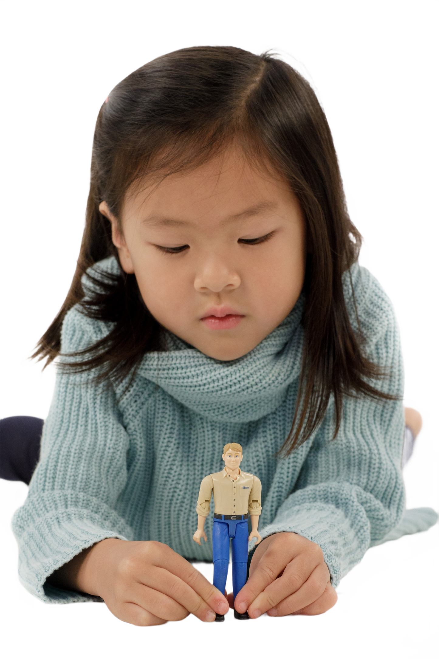 Young child in blue sweater playing with a light skin man action figure wearing blue jeans and tan shirt