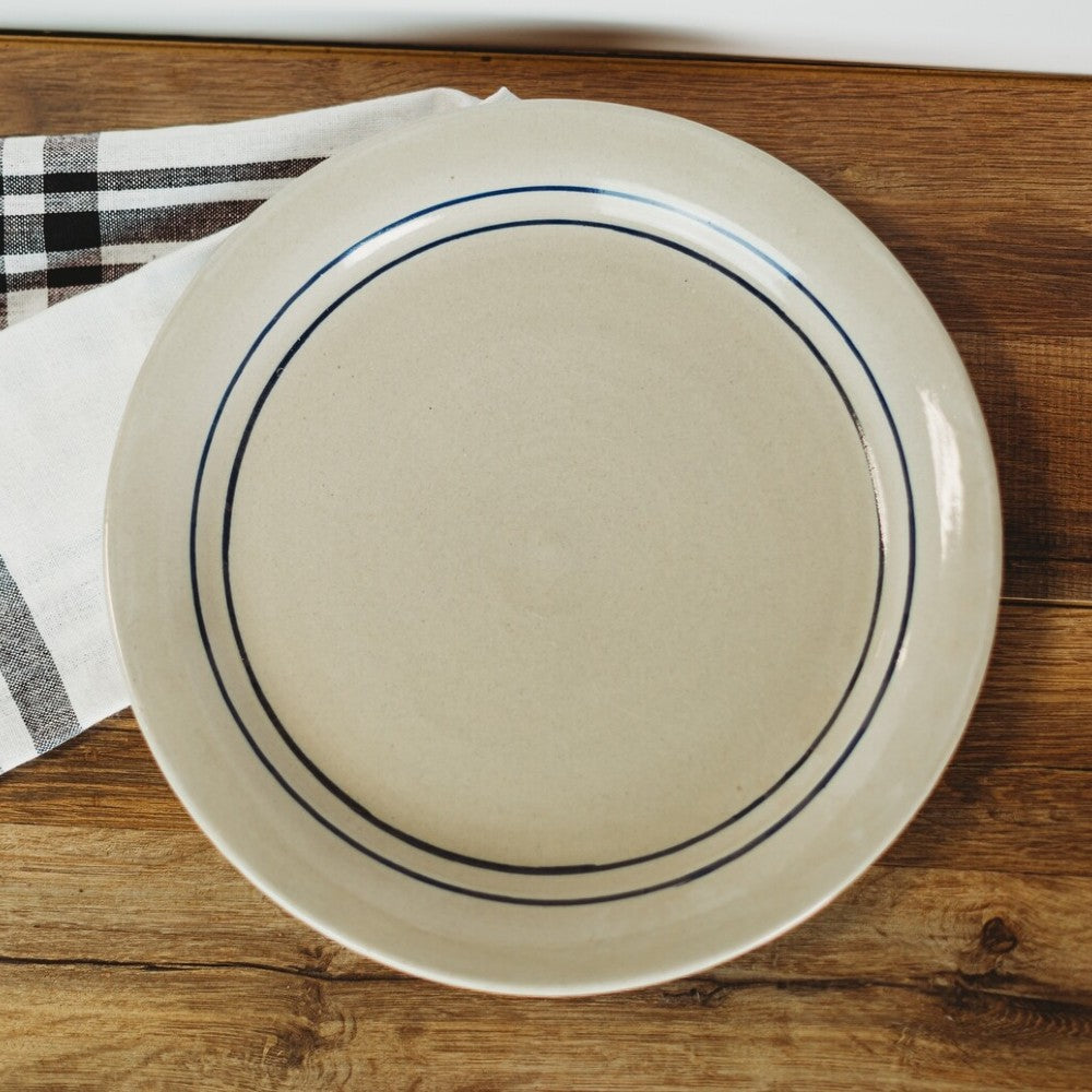 Large stoneware dinner plate with twin blue stripes on cream background, part of kitchenware and under $50 collections