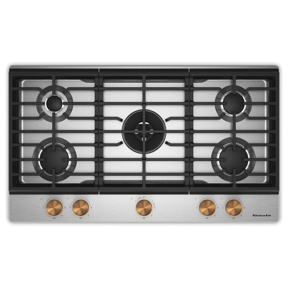 Overhead view of a stainless steel gas cooktop with five burners, integrated wok grate, and bronze-toned weighted knobs, part of KitchenAid cooktops collection in Cooktops, Gas Cooktops, Kitchen & Kitchenware, All Products, Appliances, and Ranges & Cooktops categories.