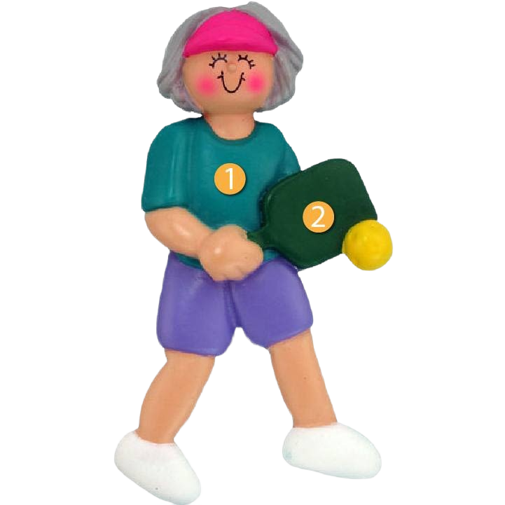 Gray-haired female figurine in teal shirt and purple shorts holding green pickleball paddle and yellow ball ornament for Christmas collection under $50