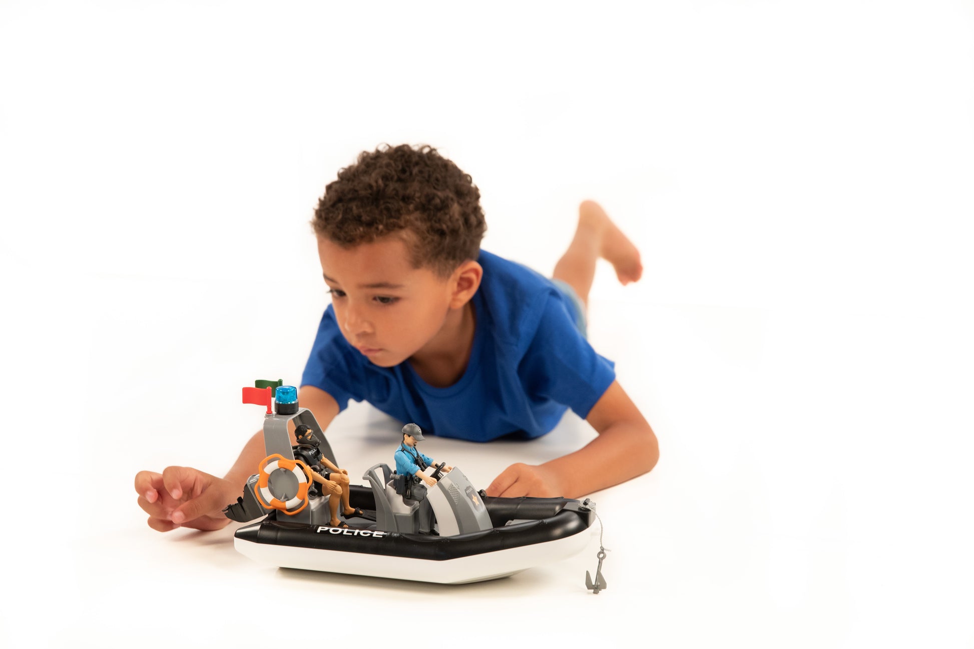 Child playing with Bruder police boat featuring rotating beacon light and two officer figures on white background