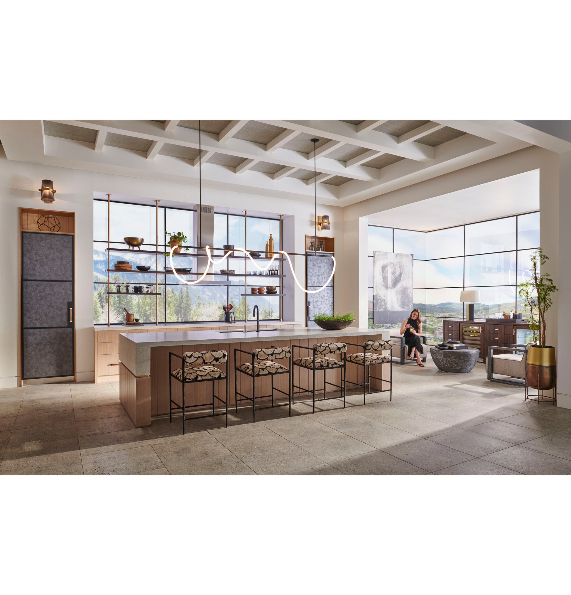 Bright open kitchen with large island, modern minimalist ovens, stone flooring, and scenic window views in appliances setting