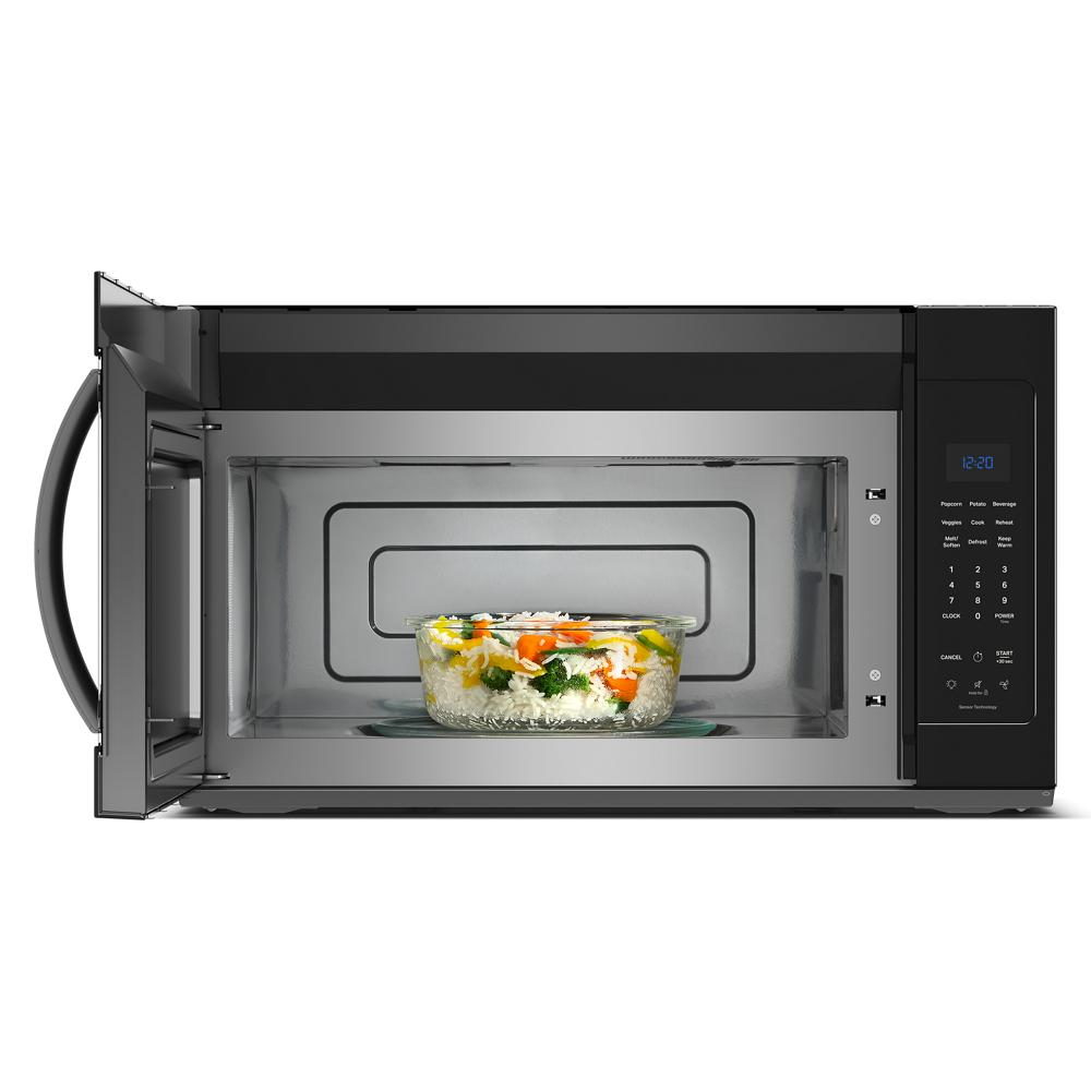 Black over-the-range microwave heating a bowl of mixed vegetables with sensor cooking in a modern kitchen setting