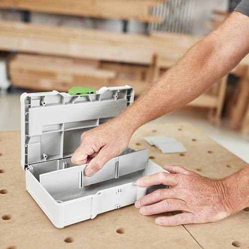 Person adjusting removable divider inside gray compact storage box for tools and home improvement tasks