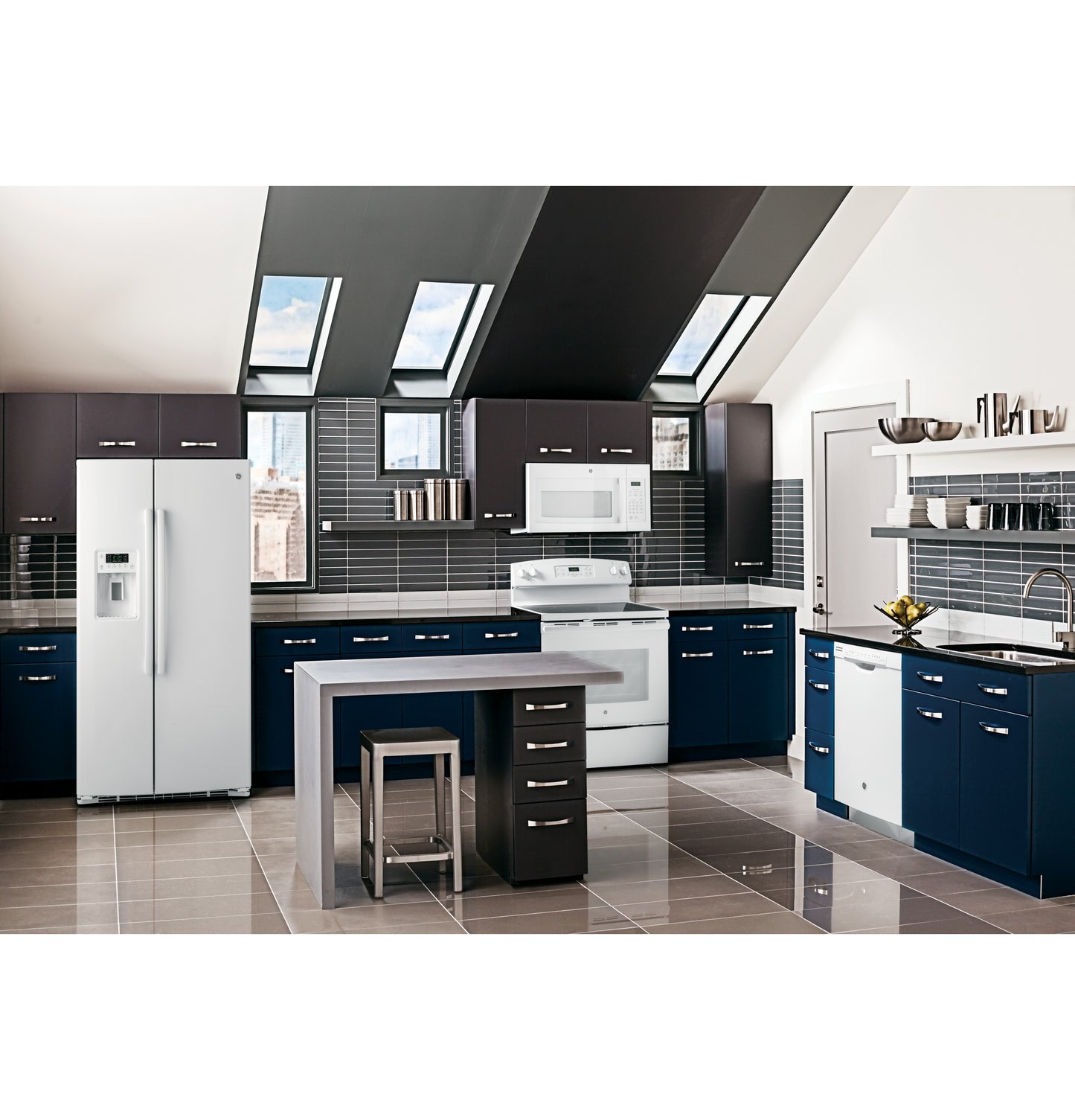Modern kitchen featuring white over-the-range microwave, navy and dark wood cabinets, and stainless steel refrigerator in appliances collection