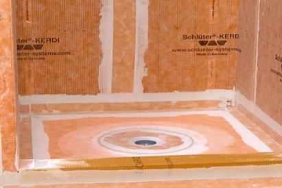 Orange Schluter KERDI waterproof membrane applied on shower walls and floor in tile flooring and home improvement project