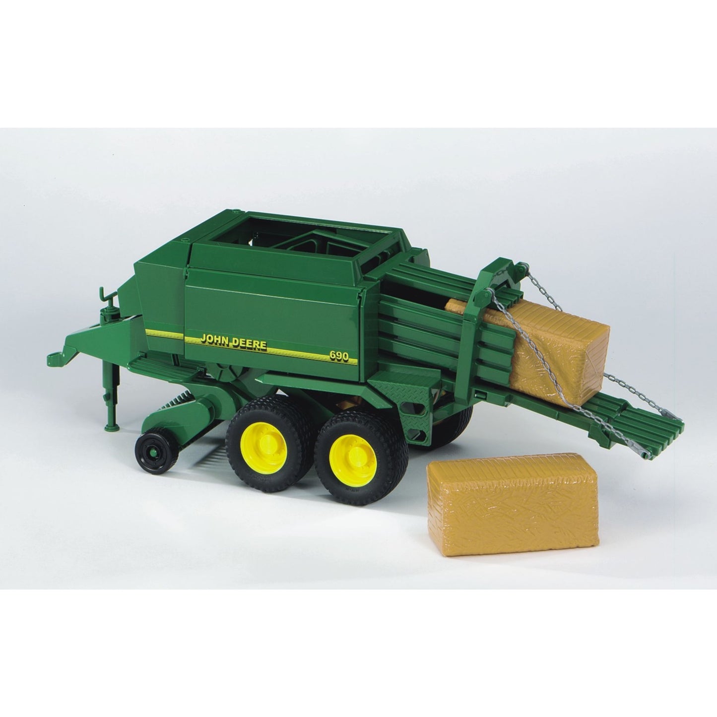 Green toy bale press with yellow wheels and large detailed bales for farming play in Bruder Toys under $100 collection