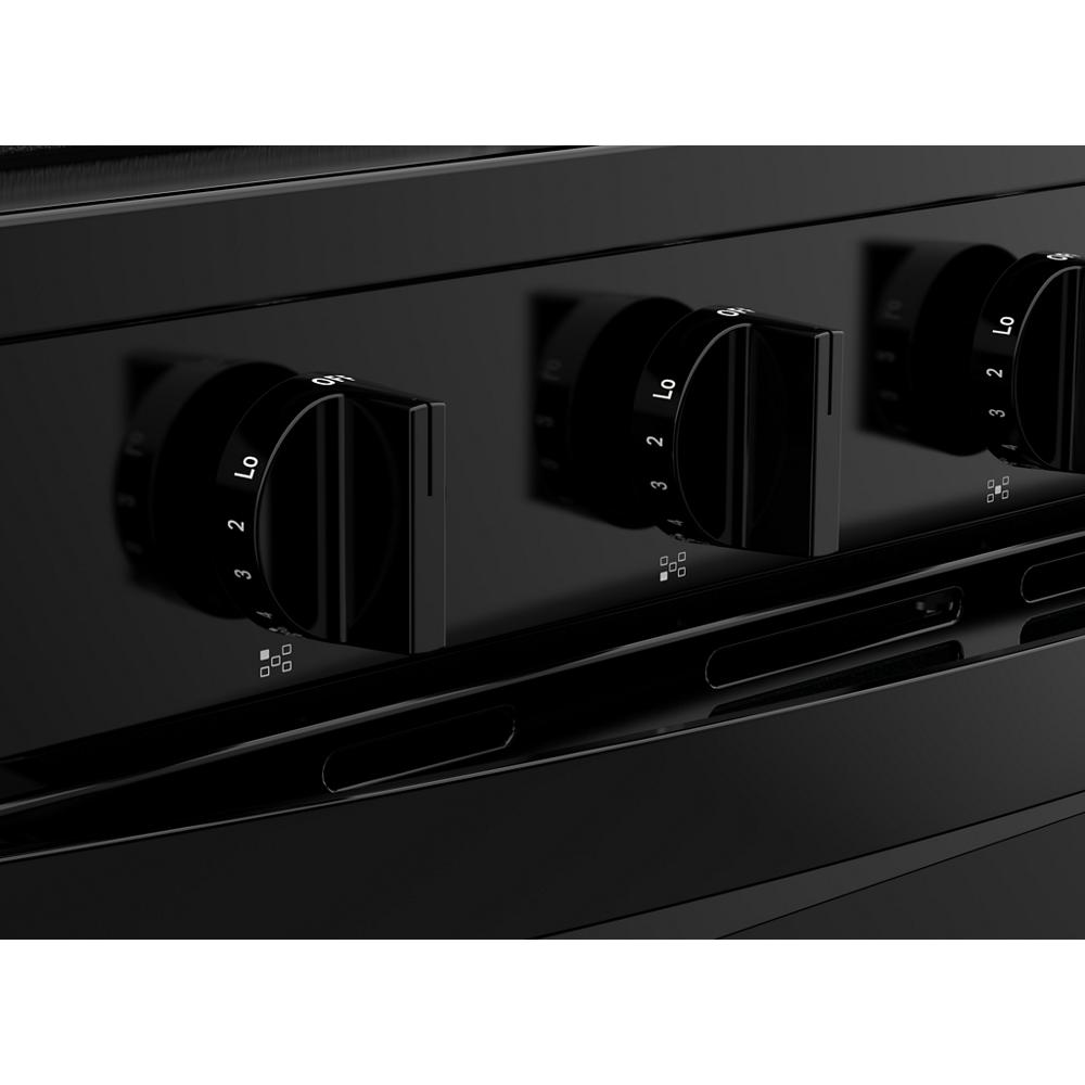 Close-up of black gas range control knobs with temperature settings for air cooking technology in kitchen appliances collection