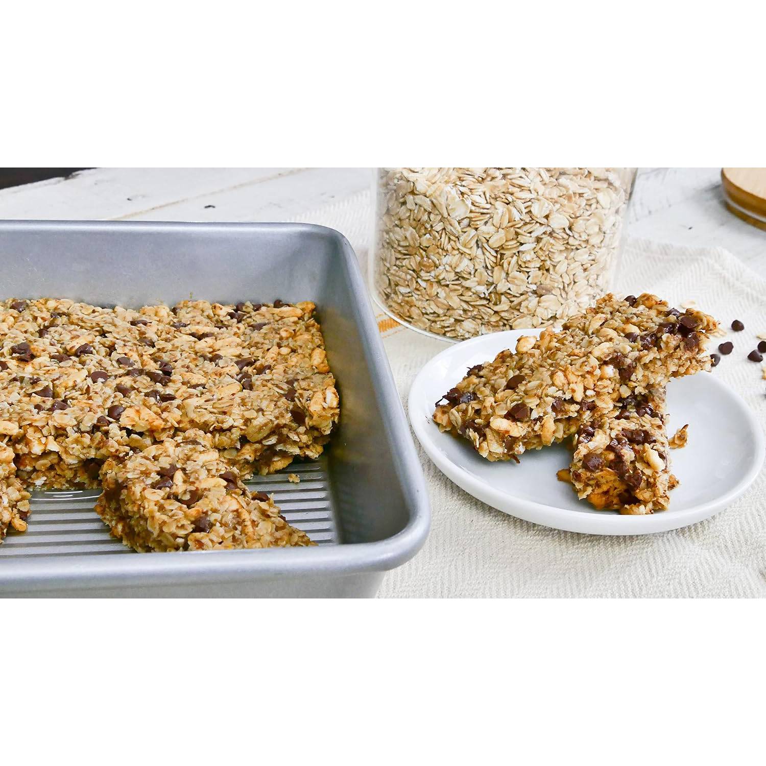 Silver rectangular cake pan with oat and chocolate chip bars on a white surface in kitchenware and bakeware collection