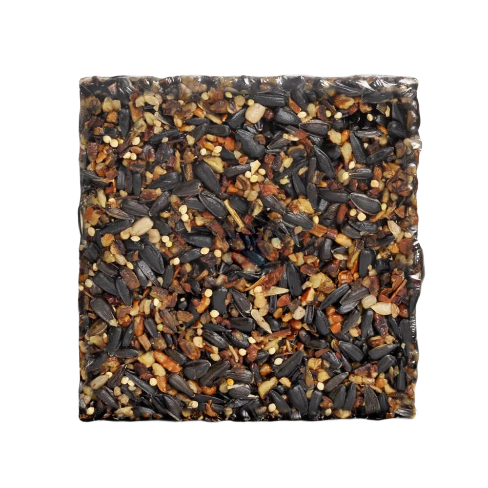 Compact square block of mixed nuts and seeds designed to provide nutrition for small wild birds outdoors