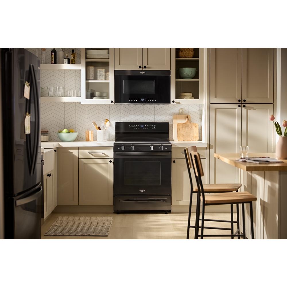 Black 30-inch electric range with digital controls, smooth cooktop, and microwave in modern kitchen setting