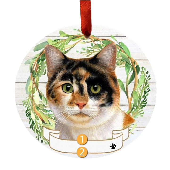 Round Christmas ornament featuring a calico cat face framed by green wreath with red hanging ribbon