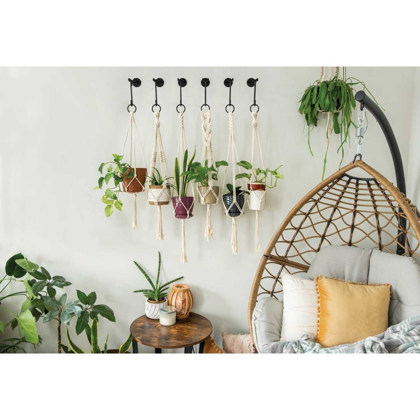 Black steel small S-hooks securing macrame hangers with various potted plants in a modern home setting