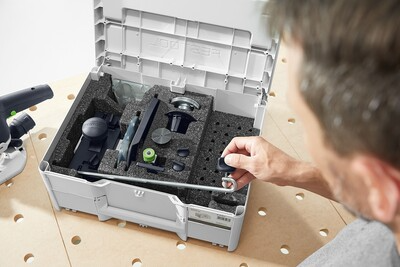 Person picking a precision tool part from a compact foam-lined storage case in a workshop setting for home improvement tasks