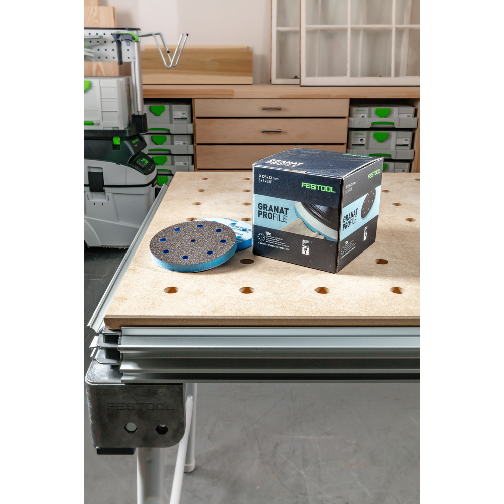 Box and blue foam-backed abrasive disc on workbench in Festool tool accessories for home improvement and power tool tasks