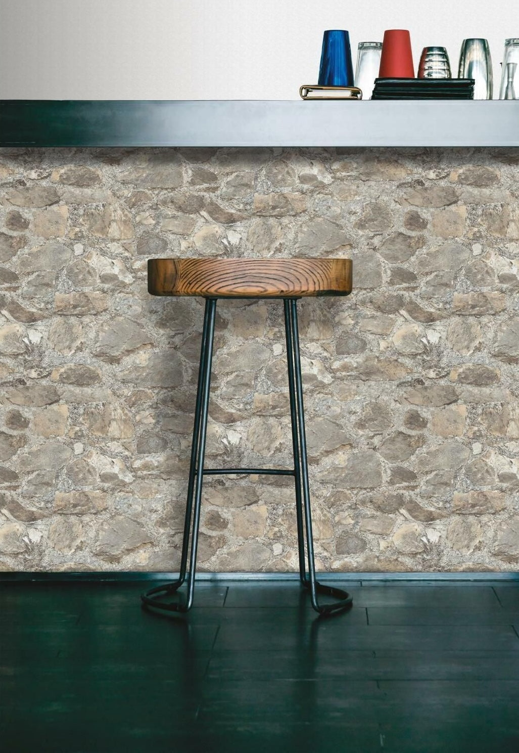 Bar stool with wooden seat and metal legs in front of weathered stone peel and stick wallpaper wall