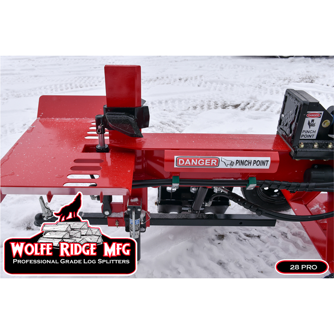 Close-up of red Wolfe Ridge professional log splitter with pinch point warning outdoors on snow-covered ground