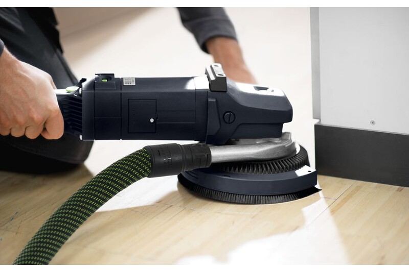 Close-up of person using a hard sanding pad attached to power sander on wood floor for home improvement tasks