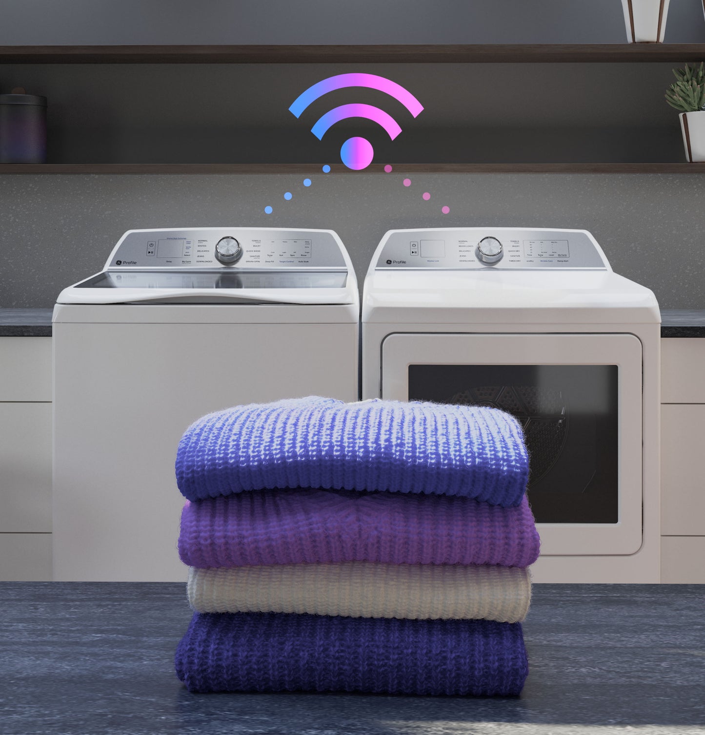 Stack of folded sweaters in front of white smart washer and dryer with wireless connectivity symbol above in home appliances collection