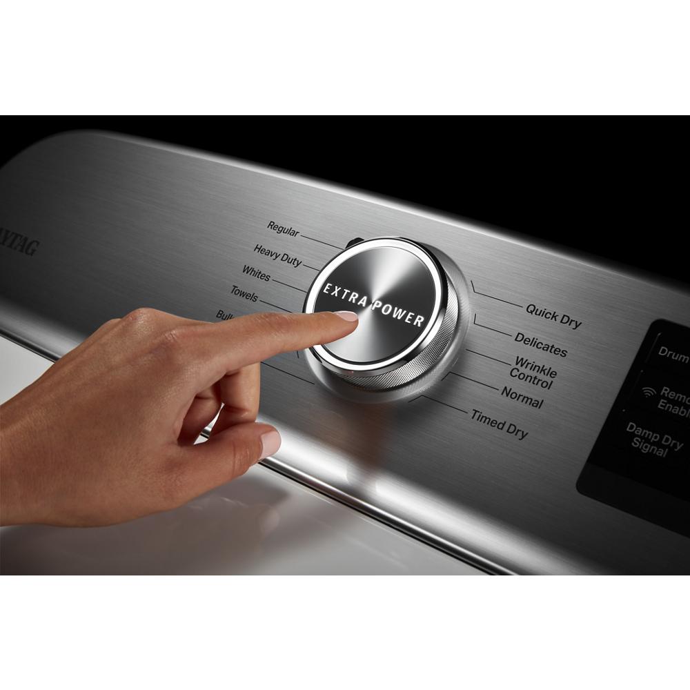 Hand pressing extra power dial on stainless steel control panel of smart top load electric dryer in dryers collection
