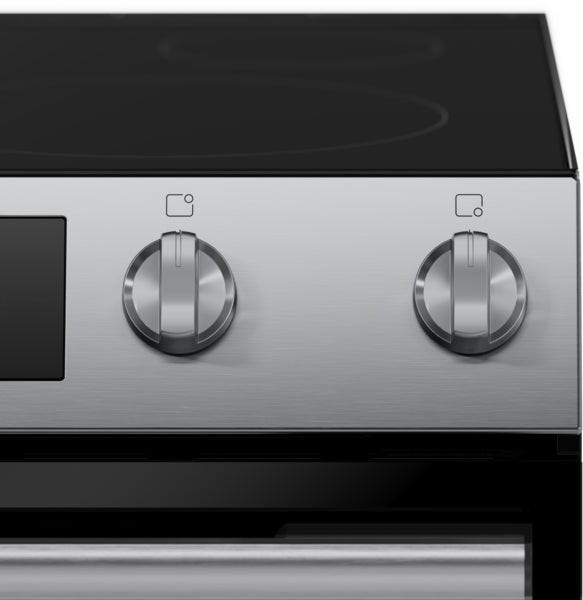Close-up of stainless steel electric range control panel with two metal knobs and black ceramic cooktop surface above