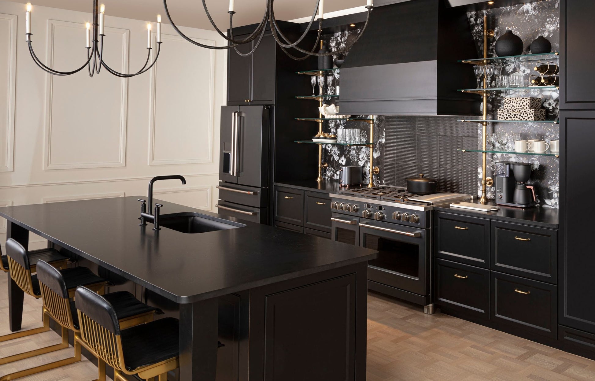 Modern kitchen with black cabinetry, large island with sink, stainless steel range, and custom hood in appliances collection