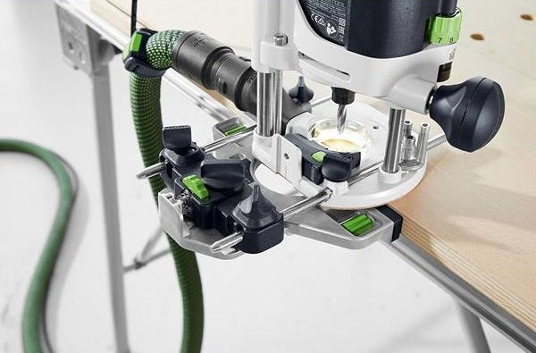Close-up of precision woodworking router attached to workbench with dust extraction hose in tools collection