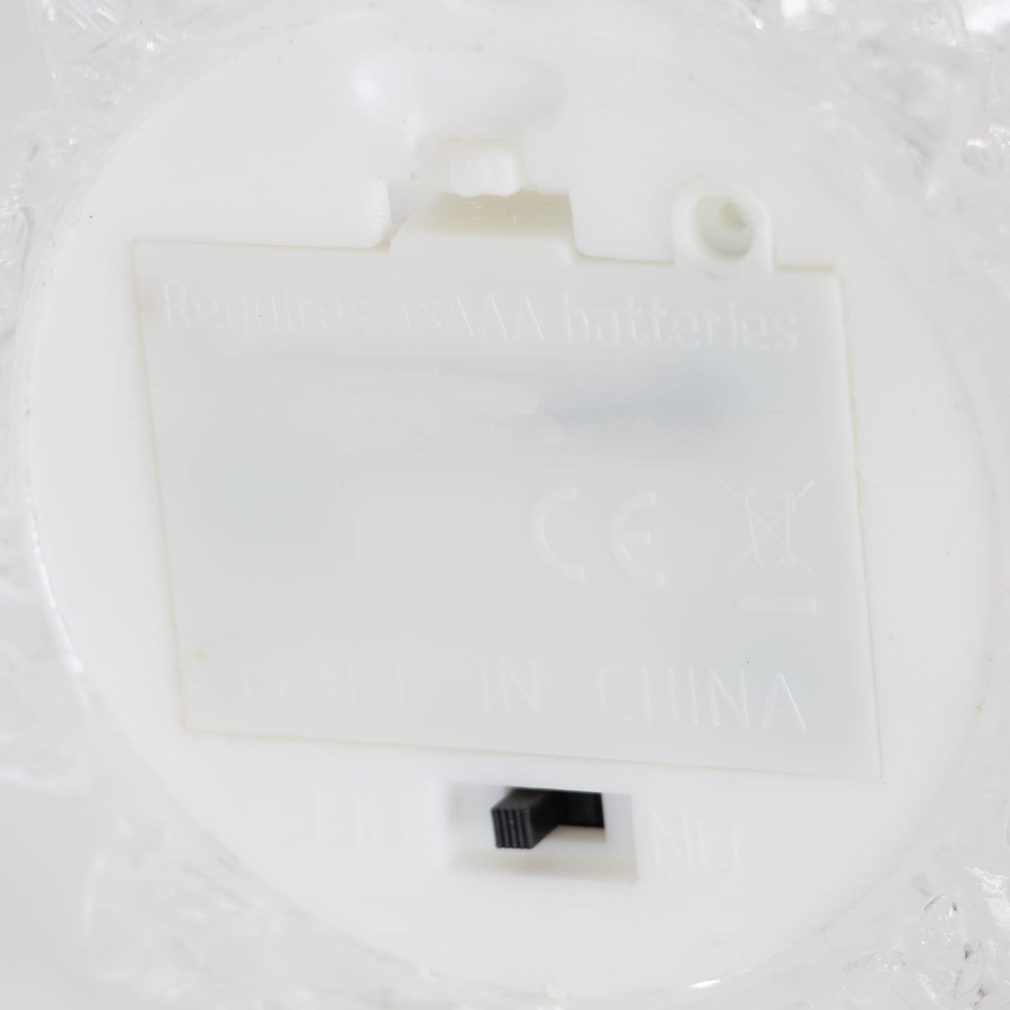 Close-up of the battery compartment and on/off switch on a light-up decorative tree for home accents