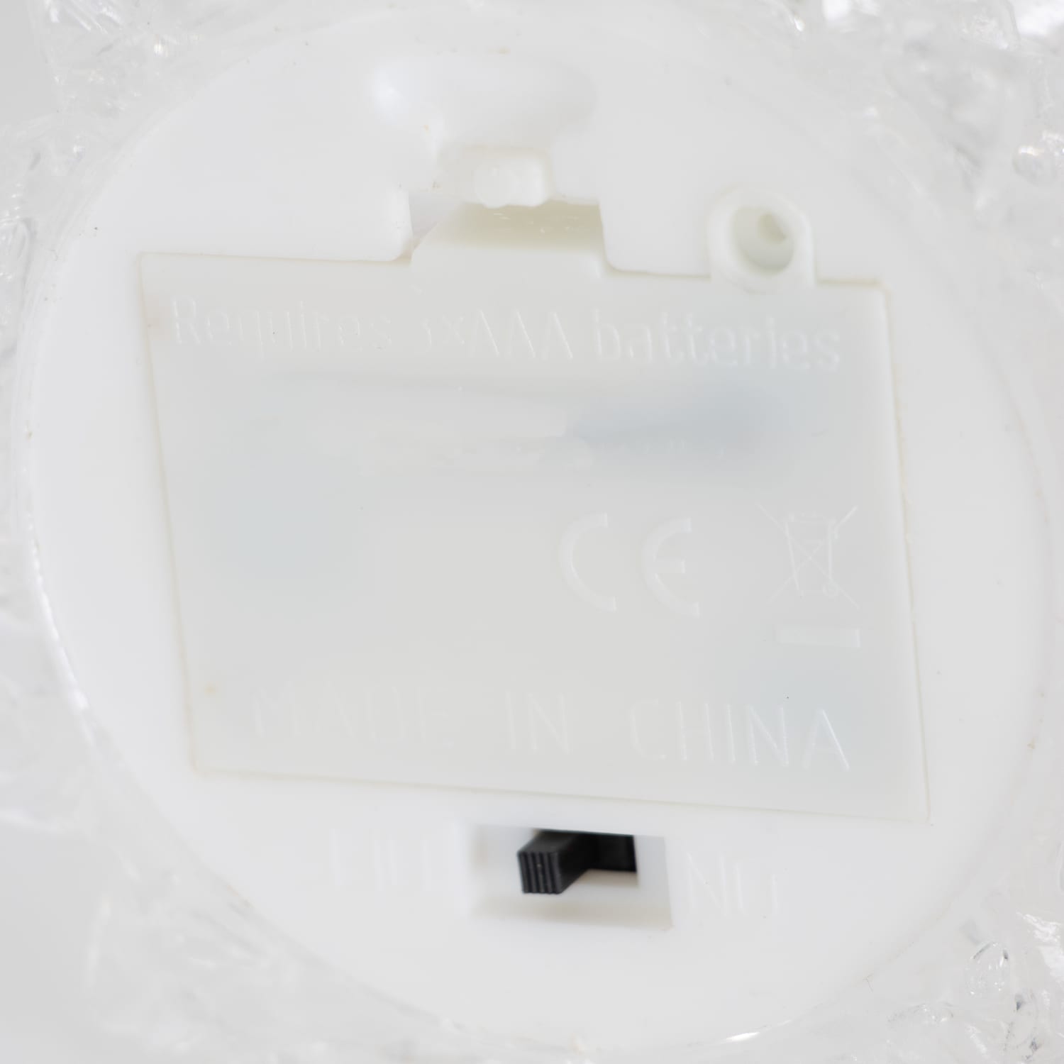 Close-up of the battery compartment and on/off switch on a light-up decorative tree for home accents