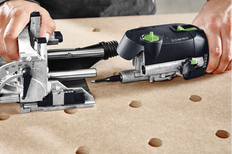 Hands operating a Festool Domino joiner tool carving precise mortises in wood, part of woodworking tool accessories collection