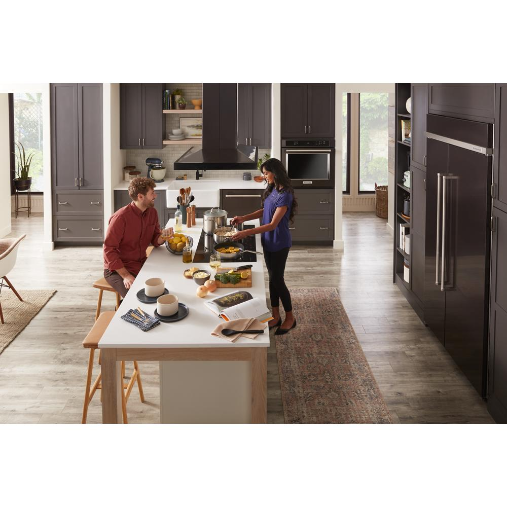 Contemporary kitchen with dark cabinetry, large island, 36-inch island-mount canopy hood, and stainless steel appliances