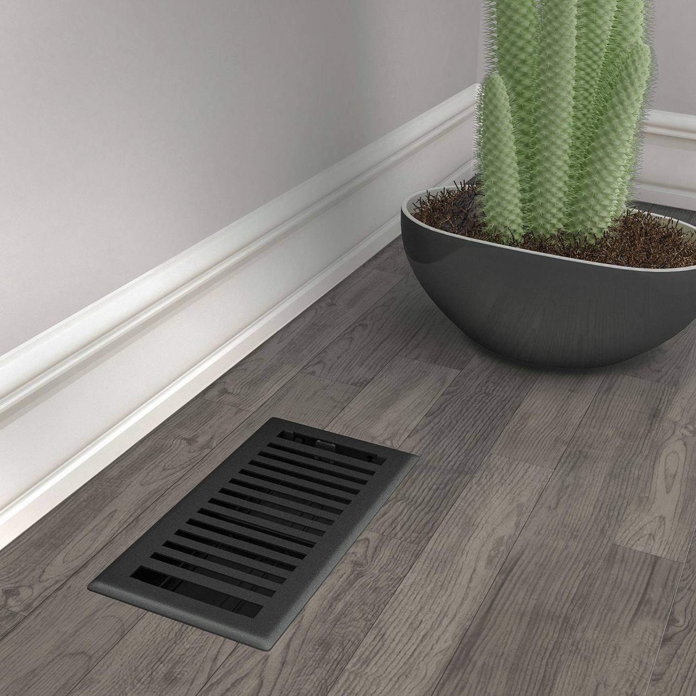 Black iron floor register vent with adjustable louvers on wood floor near planter in home improvement collections