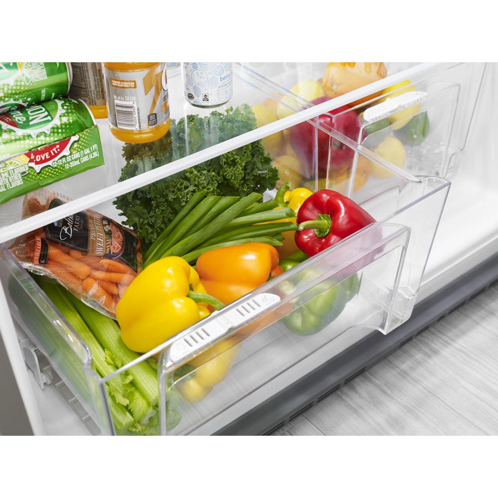 Close-up of fresh produce storage drawer with colorful bell peppers and green vegetables in a refrigerator interior