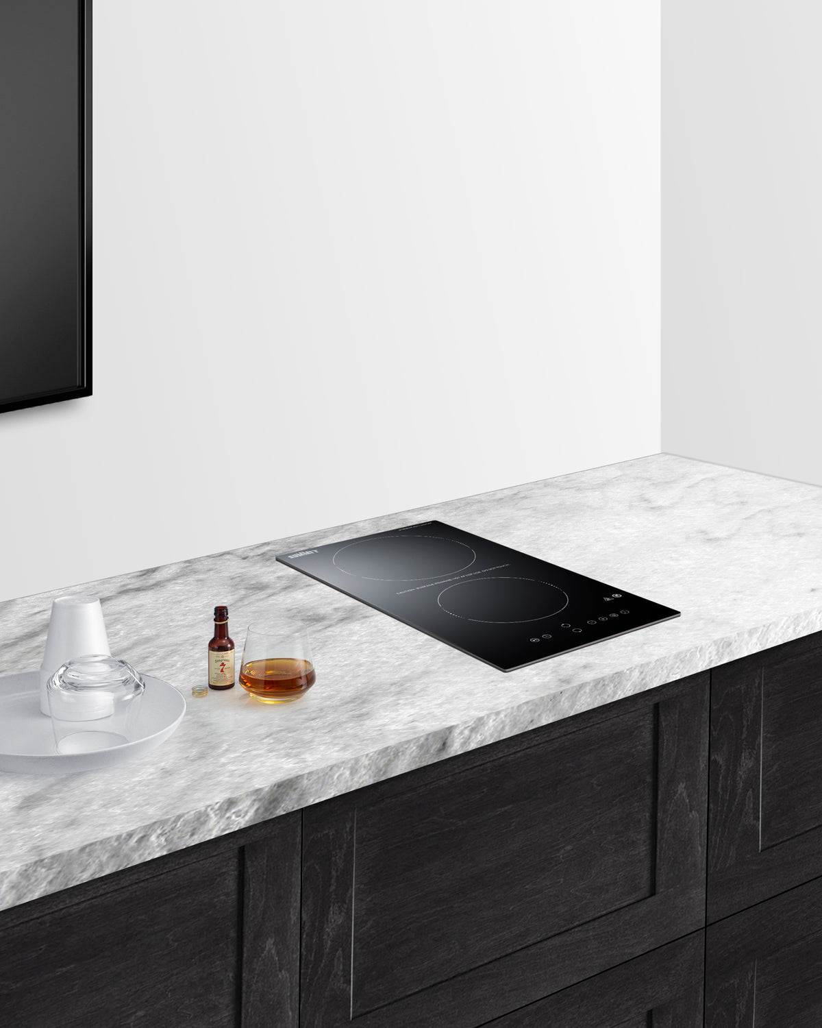 12-inch black radiant cooktop with two burners and touch controls on marble countertop in modern kitchen setting