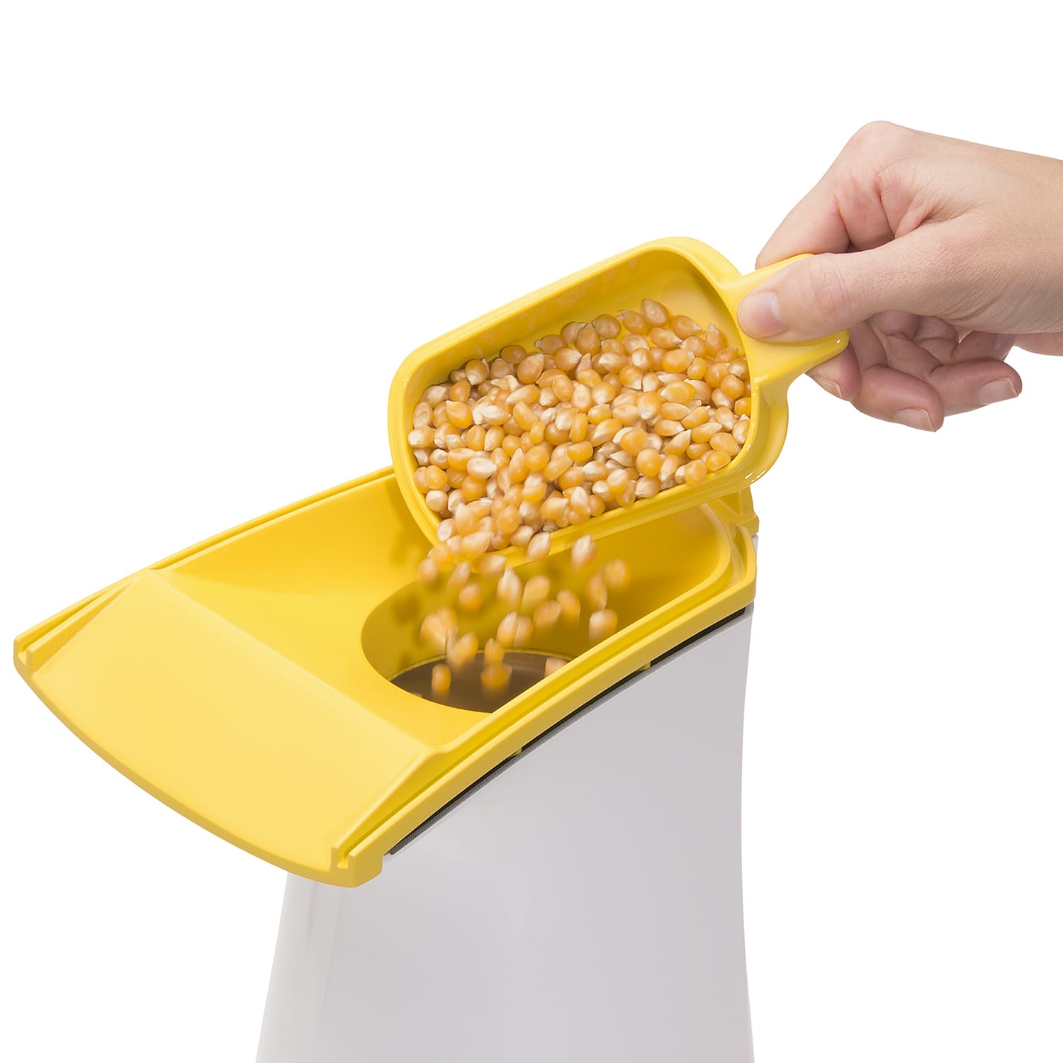 Yellow scoop pouring popcorn kernels into white and yellow hot air popcorn maker for quick snacks under $50