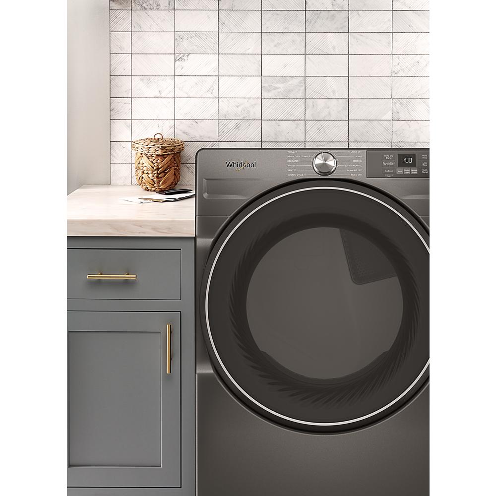 Dark gray smart front load electric dryer with digital controls shown next to gray cabinet in laundry appliances collection