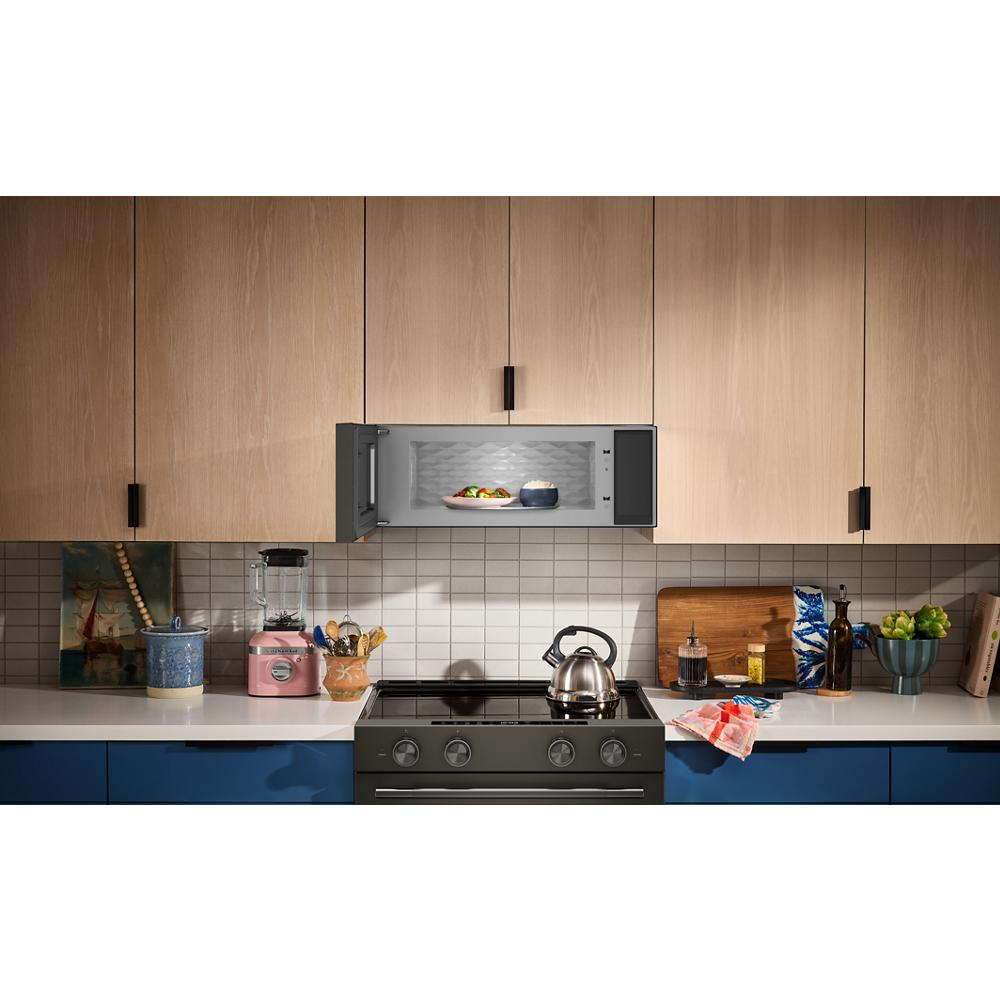 Black low profile microwave hood with open door and illuminated interior above gas range in modern kitchen setting